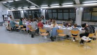 Na fotografiji so udeleženci delavnice med pripravo prazničnih voščilnic in voščil v knjižnični dvorani. 