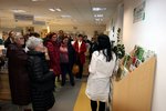 Udeleženci dogodka ob Knjižnici semen v pritličju knjižnice ob izposojevalnem pultu.